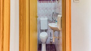 Ein Badezimmer mit Toilette, Waschbecken und Spiegel.