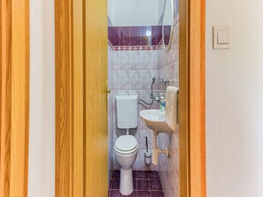 Ein Badezimmer mit Toilette, Waschbecken und Spiegel.