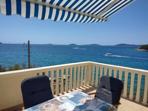 A balcony with a view of the sea, two chairs, and a table with a patterned tablecloth. - Apartments Blaza - Duplex Two Bedroom Apartment (Vodice)