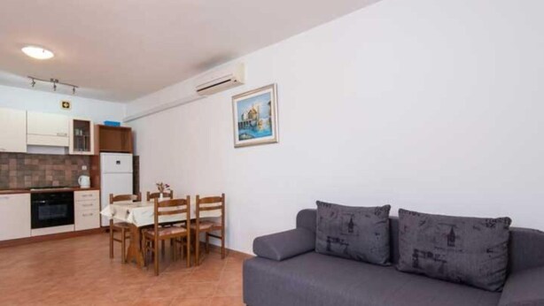 A compact living space with a kitchenette, dining area, and a sofa. - One Bedroom Apartment With Terrace and Sea View (Ston)