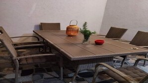 A dining area with a long table, wicker chairs, a small potted plant, and a red bowl. - Apartment Barbara - Two Bedroom Apartment With Terrace (Vir)