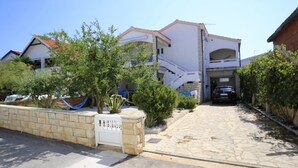 A residential property with a paved driveway, a garage, and a stone wall. - Apartment Barbara - Two Bedroom Apartment With Terrace (Vir)