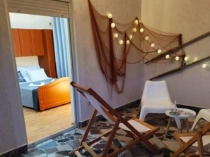 A room with a bed, a small table, and a chair. There is a staircase with string lights. - Apartment Barbara - Two Bedroom Apartment With Terrace (Vir)