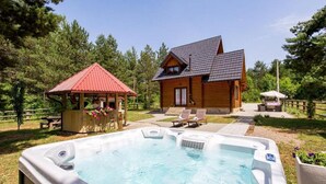 A hot tub in a backyard with a wooden house and a gazebo. - Apartments Plitvice Forest - Superior One Bedroom Apartment With Terrace (Plitvicka Jezera)