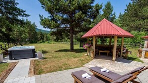 A patio area with a hot tub, lounge chairs, and a gazebo. - Apartments Plitvice Forest - Superior One Bedroom Apartment With Terrace (Plitvicka Jezera)