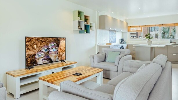 A modern living room with a flat-screen TV, a wooden coffee table, and a grey sofa. - Luxury 3BR Pool Villa • 3 Baths • Villa Twin B (Noord)