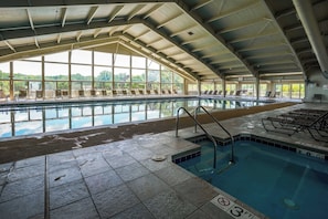 An indoor swimming pool with clear glass walls, a tiled floor, and a no diving sign. - Abbey Springs Pool & Beach Condo (Fontana)