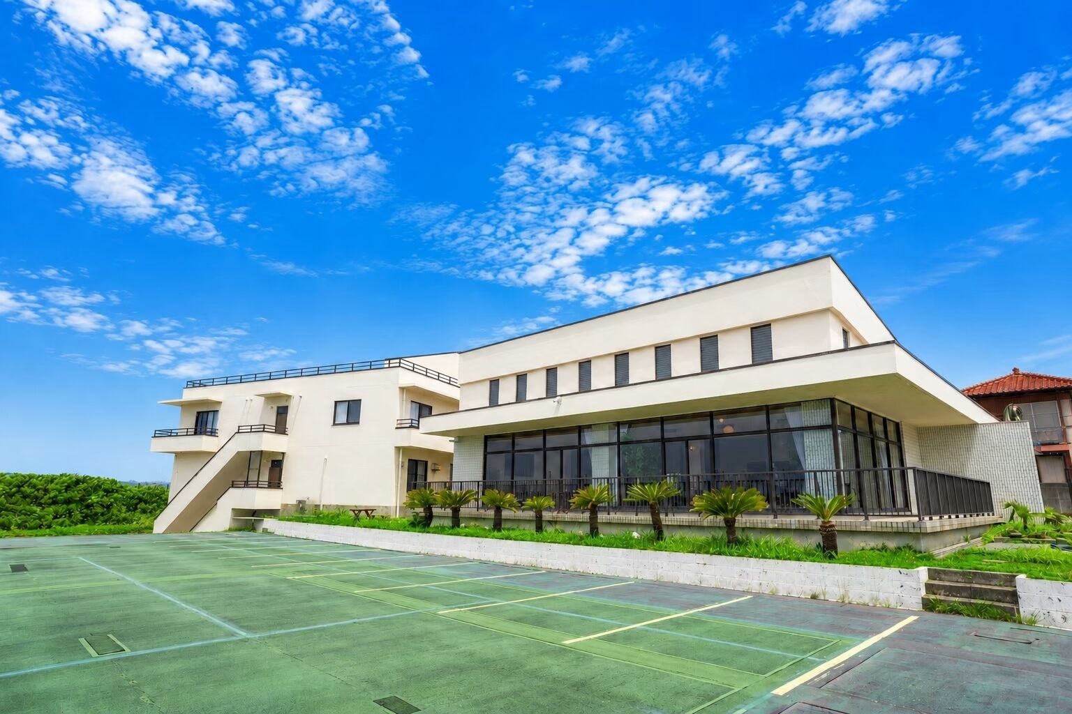 Un edificio moderno con techo plano, ventanas amplias y fachada uniforme.