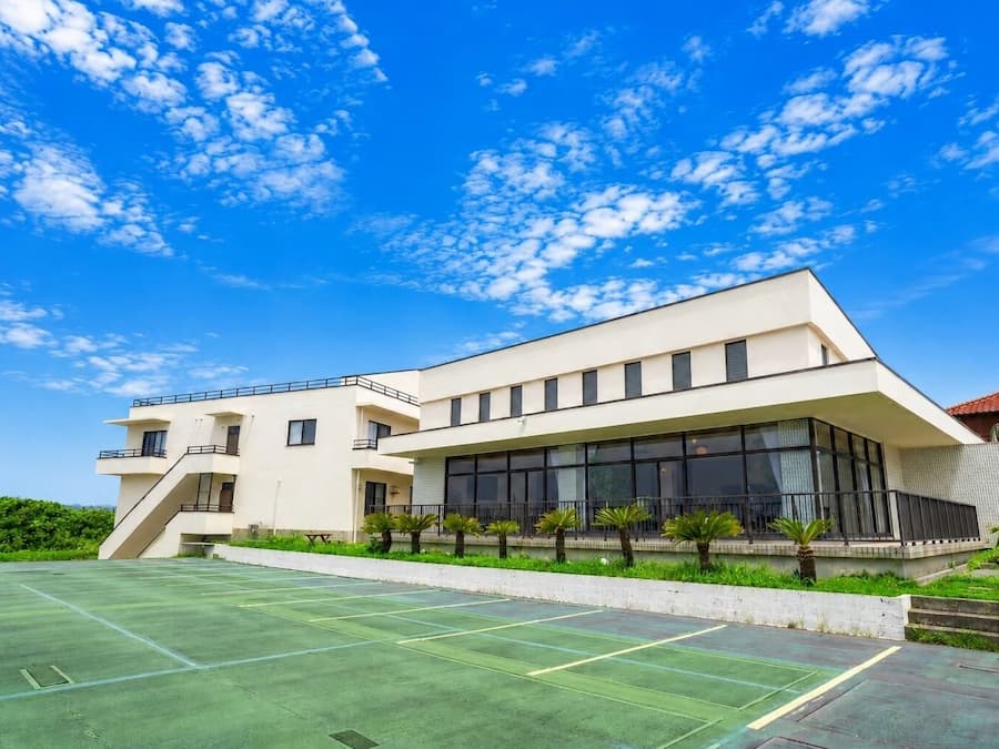 A modern building with a flat roof, large windows, and a flat facade.