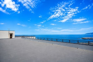 Une terrasse sur le toit offrant une vue dégagée sur l’océan et une ligne côtière lointaine.