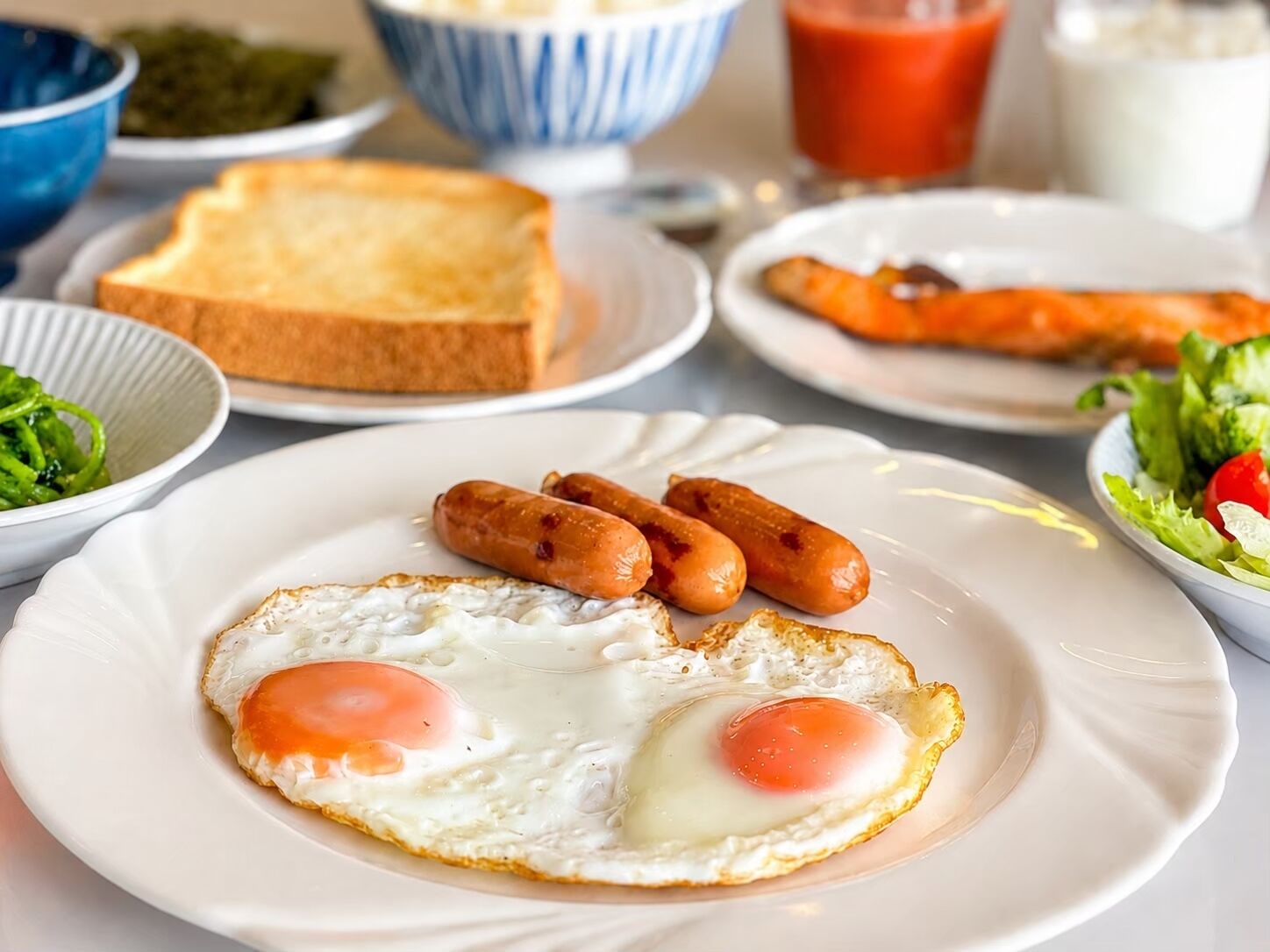 A breakfast plate with eggs, sausages, toast, and a side salad.