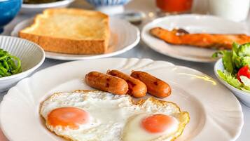 A breakfast plate with eggs, sausages, toast, and a side salad.