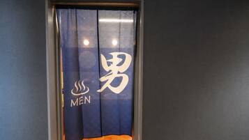 A room with a dark blue curtain featuring a logo and the word 'MEN' on it.