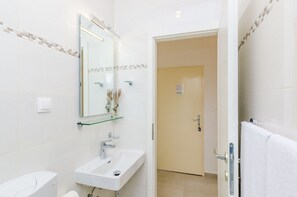 A modern bathroom with a white sink, a mirror, and a toilet. - Rooms Batina - Double Room-1 (Dubrovnik)