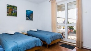 A room with two beds, a window with curtains, and two paintings on the wall. - Plavi Zal Apartment - One Bedroom Apartment With Two Terraces (Dubrovnik)