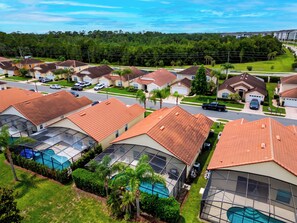 A residential area with multiple houses, each featuring a red-tiled roof and a swimming pool. - Private Screened Pool + BBQ + Outdoor Dining | Near Disney | Palm & Preserve (Davenport)