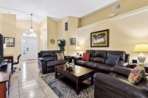A living room with a sofa set, a coffee table, and a lamp. - Private Screened Pool + BBQ + Outdoor Dining | Near Disney | Palm & Preserve (Davenport)