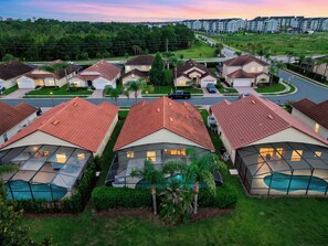 A residential area with houses featuring red-tiled roofs and a swimming pool. - Private Screened Pool + BBQ + Outdoor Dining | Near Disney | Palm & Preserve (Davenport)