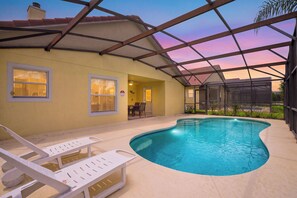 Un espace extérieur abrité avec une piscine, des chaises longues et une table de patio.