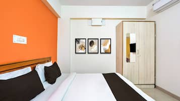 Una habitación de hotel con cama, armario y tres cuadros en la pared.