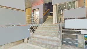 Una escalera con barandillas de metal que sube a un piso superior.