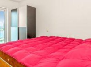 A bedroom with a large bed, a window, and a door. - Three Bedroom Apartment With Balcony and Sea View (Crikvenica)