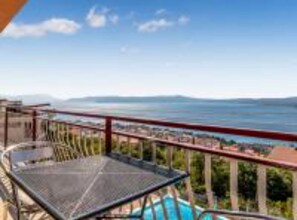 A balcony with a view of a swimming pool and a distant landscape. - Three Bedroom Apartment With Balcony and Sea View (Crikvenica)