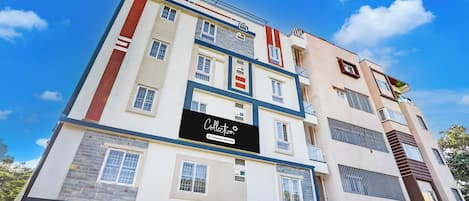 Un edificio de varios pisos con un letrero que indica 'Collection Company-Serviced'.
