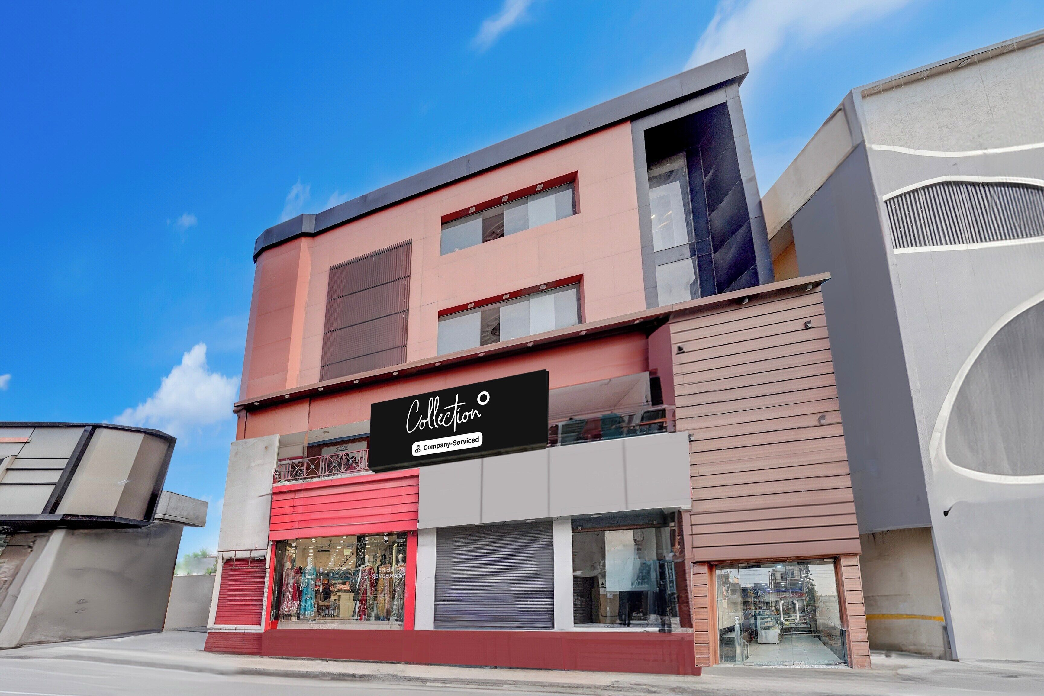 A modern building with a storefront, a company-serviced sign, and a clear sky.