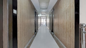 Ein langer, schmaler Korridor mit Fliesenboden und Holzwandverkleidung.
