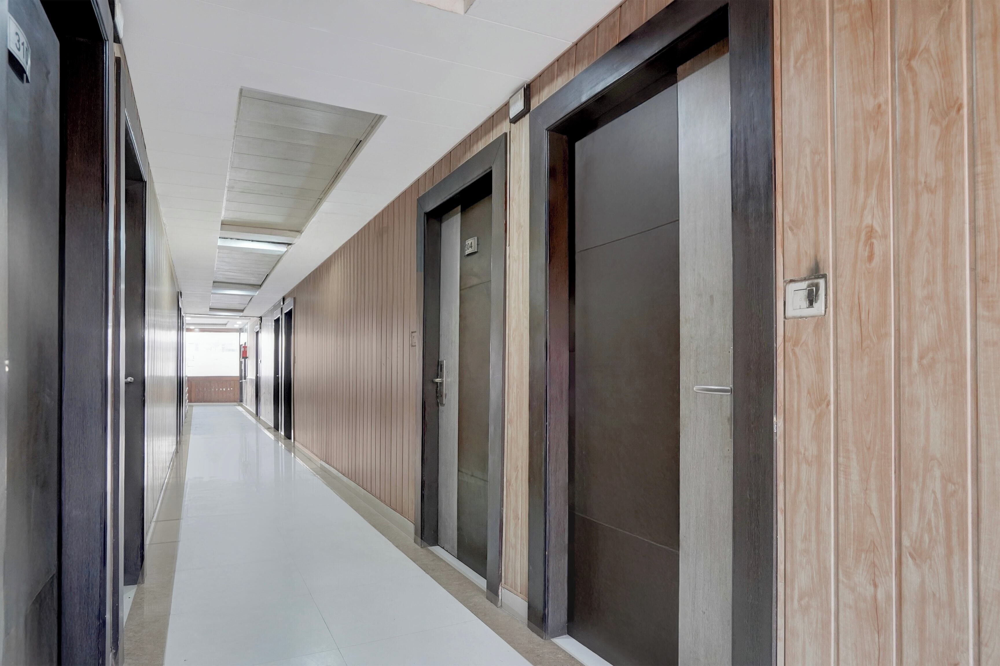 A long, narrow hallway with doors on one side and a tiled floor.