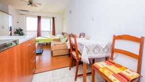 Un espacio habitable compacto con kitchenette, comedor y sofá.