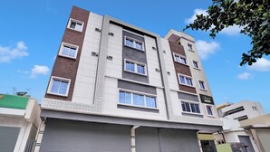 A multi-story building with a flat facade, large windows, and a gated entrance. - Collection O K R Puram (Bangalore)