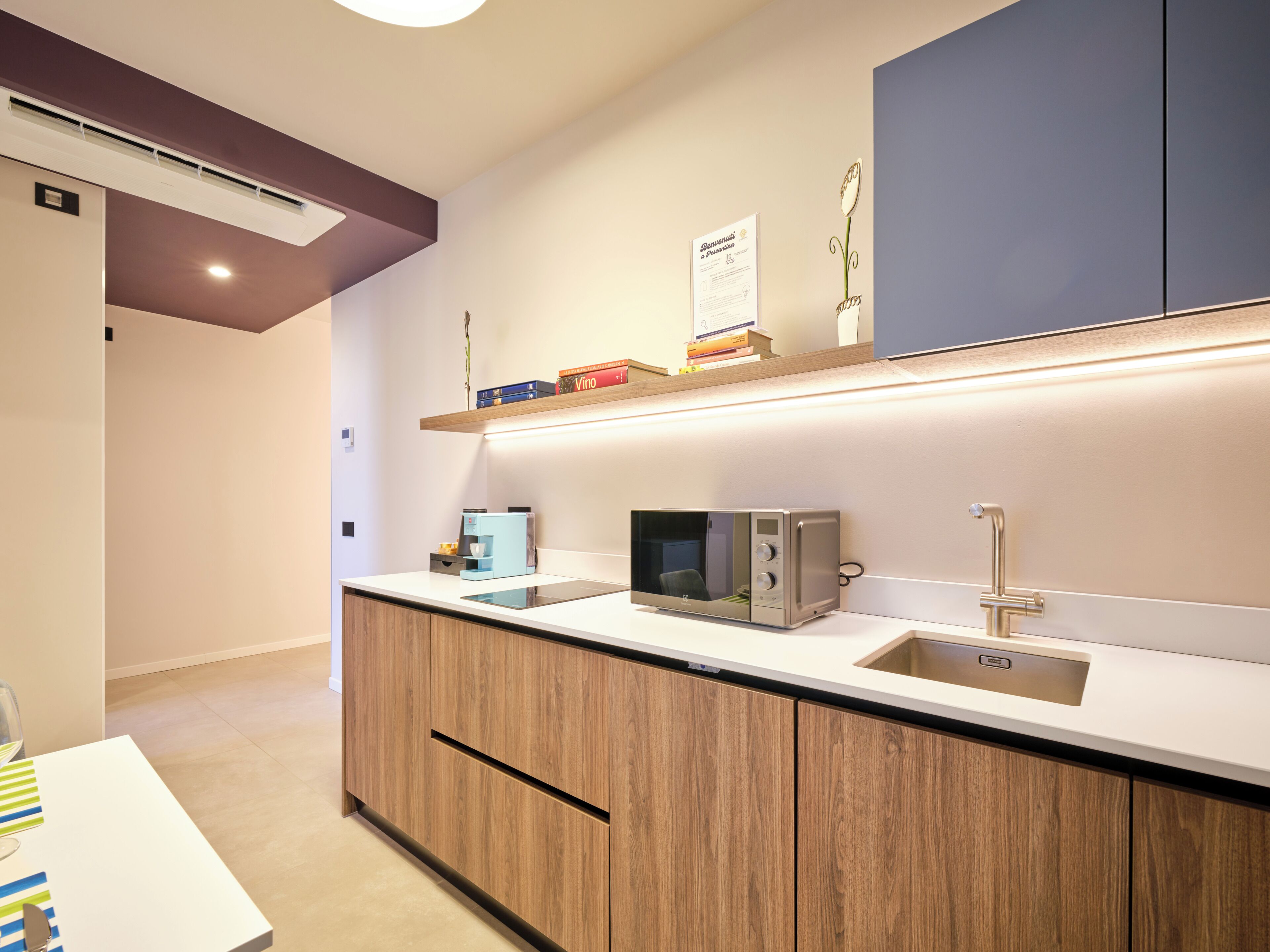 A modern kitchen with built-in appliances, wooden cabinets, and a countertop.