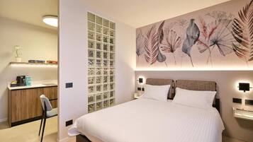 Un dormitorio moderno con una cama grande, mesitas de noche, un escritorio y un panel decorativo en la pared.