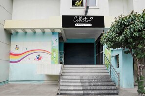 A building entrance with a staircase leading up to a closed door. - Collection O Peenya 2nd stage (Bengaluru)