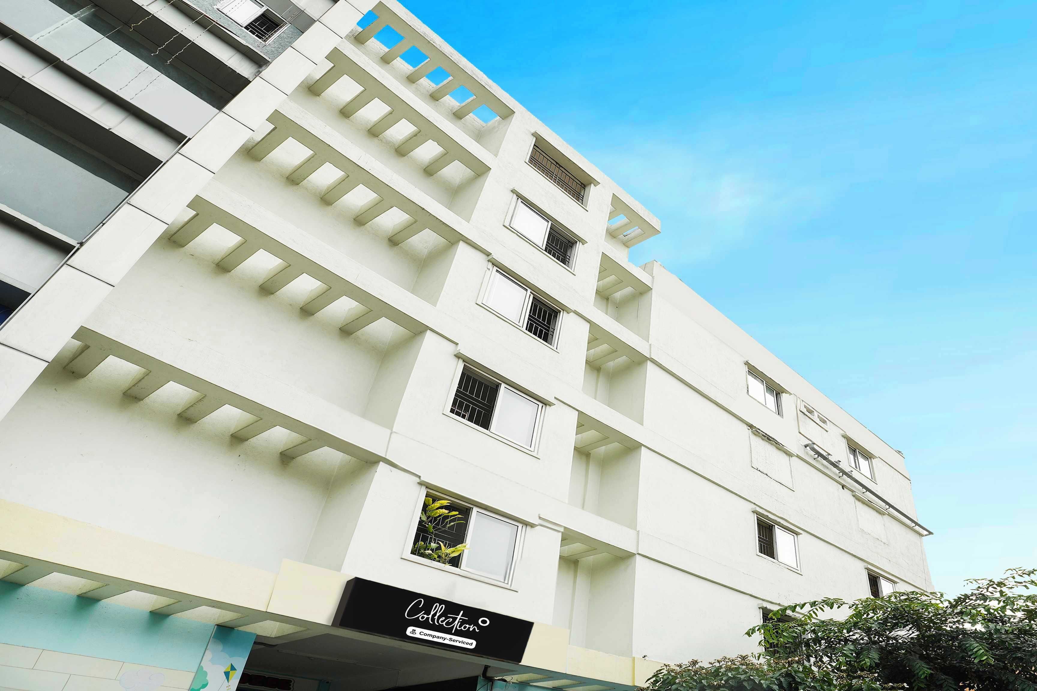 A multi-story building with a flat facade, several windows, and a sign indicating a company service.