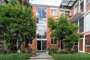 A modern building with a glass facade, brick walls, and a central entrance with steps. - Bright Homely 2BR in St Kilda East w Parking (Saint Kilda East)