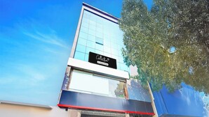 A modern building with a glass facade and a sign indicating it is a company-serviced location. - Collection O KR Puram Ayyappa Nagar (Bengaluru)