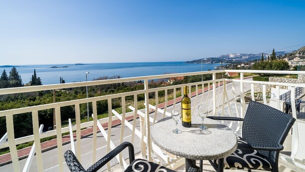 A balcony with a table and chairs overlooking a coastal view. - Villa Samba - Standard One-bedroom Apartment With Balcony and Sea View (Zupa dubrovacka)