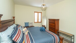 A bedroom with a large bed, a dresser, a nightstand, a lamp, and a window with blinds. - Villa Pero and Jele With Terrace (Zupa dubrovacka)