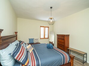 A bedroom with a large bed, a dresser, a nightstand, a lamp, and a window with blinds. - Villa Pero and Jele With Terrace (Zupa dubrovacka)