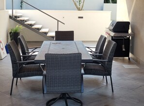 A modern outdoor dining area with a rectangular table and four wicker chairs, a staircase, and a grill station. - Villa Pero and Jele With Terrace (Zupa dubrovacka)
