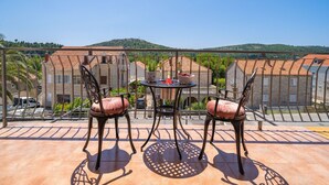 A terrace with a table and chairs, overlooking a hillside with buildings. - Villa Pero and Jele With Terrace (Zupa dubrovacka)