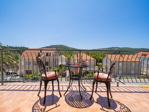 A terrace with a table and chairs, overlooking a hillside with buildings. - Villa Pero and Jele With Terrace (Zupa dubrovacka)