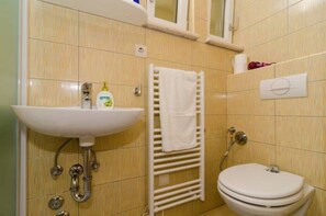 Ein Badezimmer mit Waschbecken, Handtuchhalter und Toilette.