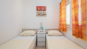 A bedroom with two single beds, a nightstand with a lamp, and a painting on the wall. - Apartment Bella Vista - Two Bedroom Apartment With Terrace (Marina)