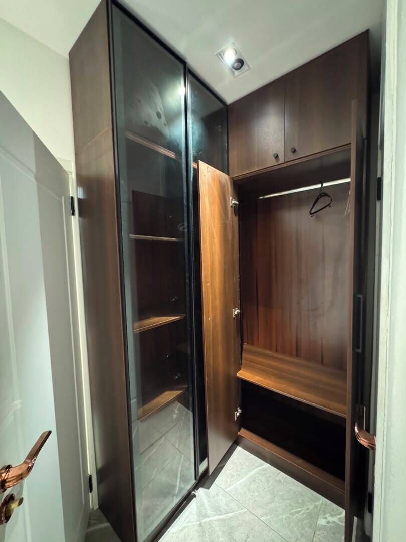 Un vestidor con puertas correderas, estantes empotrados y barra para colgar.
