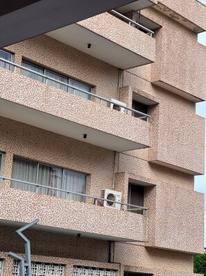 A multi-story building with balconies, air conditioning units, and a patterned facade. - SM LUSSO (Lagos)
