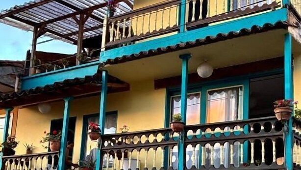 Un edificio de varios pisos con balcones, puertas y ventanas.